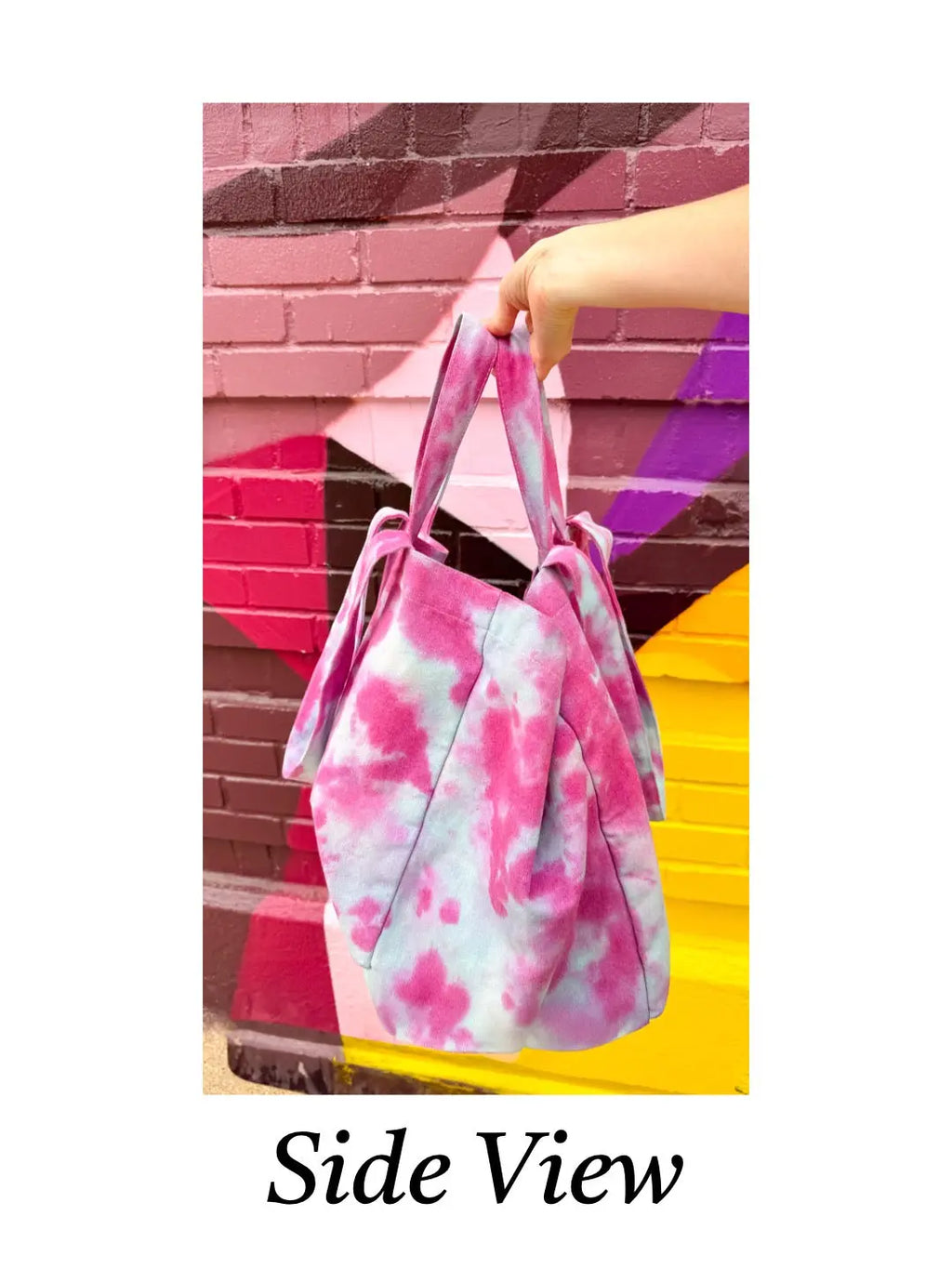 Tie-dye bag held by a hand with a colorful background
